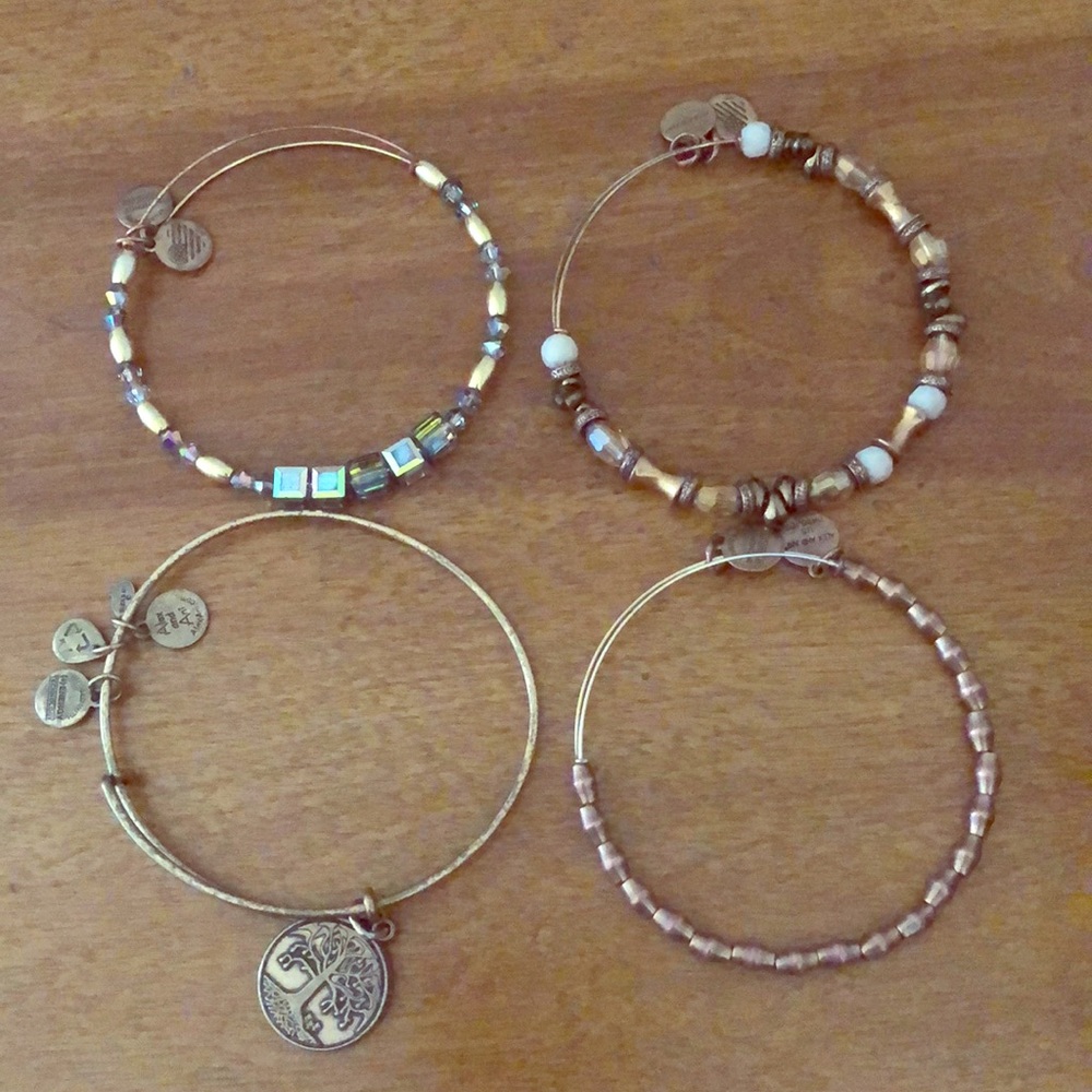 Four beautiful gold tone Alex and Ani bracelets.